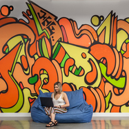 Employee working in front of mural